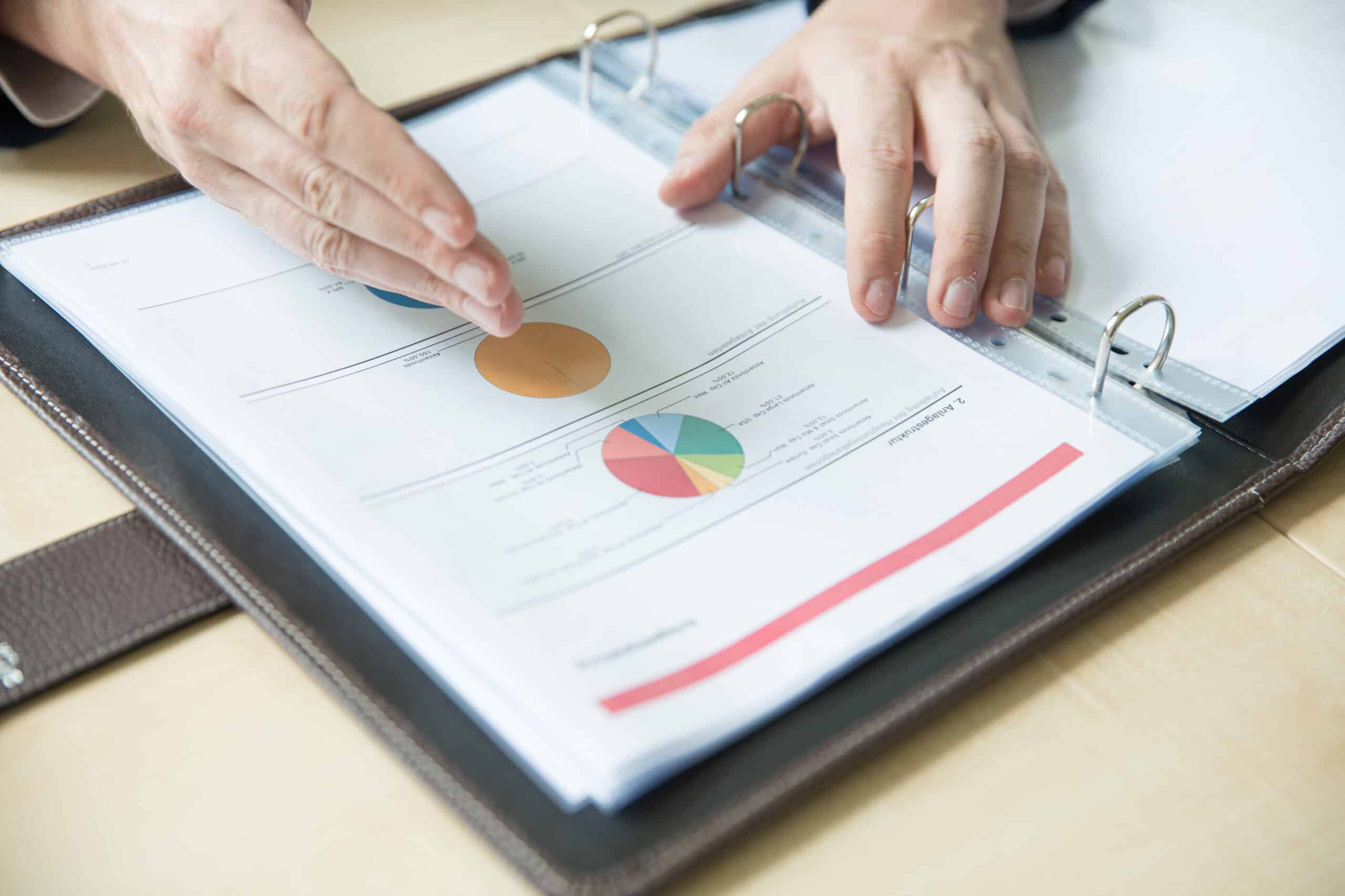 Beratungsunterlagen mit Diagrammen und Finanzdokumenten in einem Kundengespräch